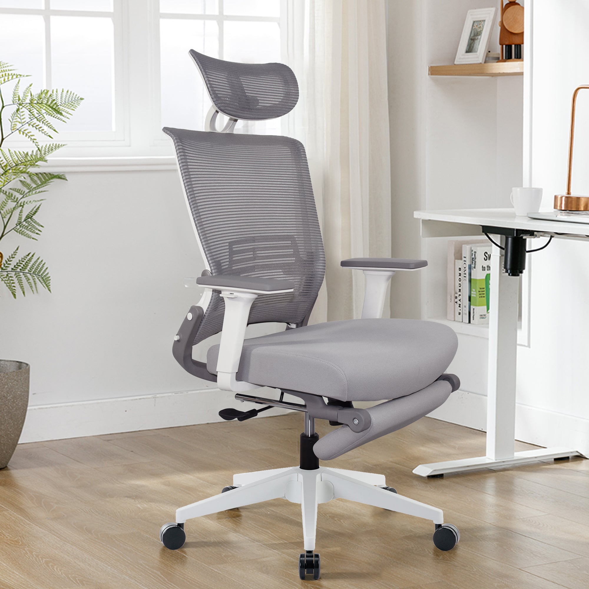 An ergonomic chair with armrests that can be folded and placed under a table