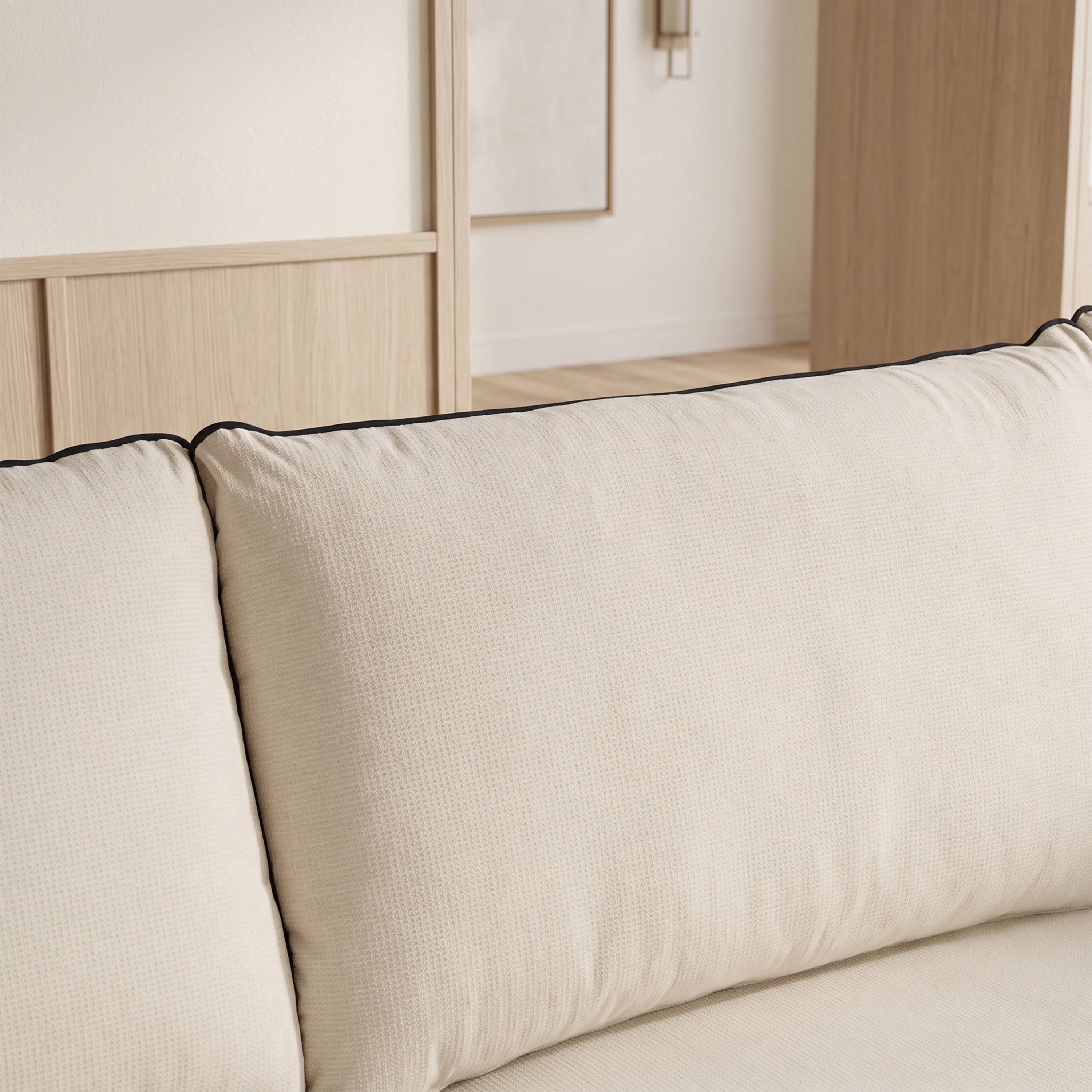 Cream sofa backrest and seat cushions with piped trim along the corners