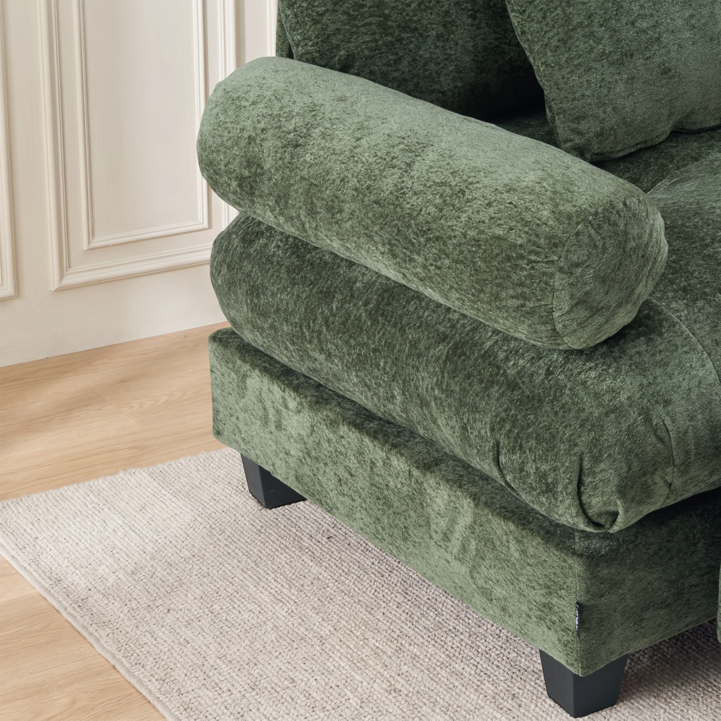 Green plush chaise ottoman with padded armrest and thick cushioned base