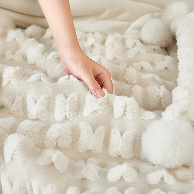 Cream plush throw pillow with raised texture and pom-pom trim