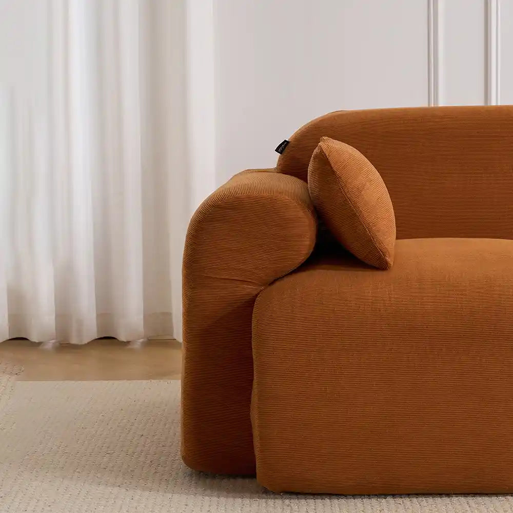 Burnt orange corduroy loveseat sofa close-up of rounded arm and bolster cushion