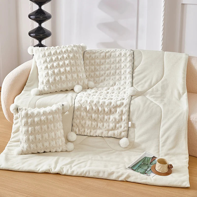 Cream plush throw pillow set with waffle texture and pom-pom corner accents